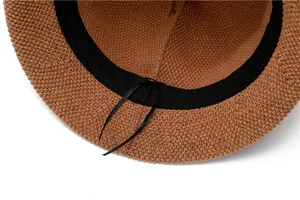 Detail view of the brown straw hat's interior with sweatband and adjustable drawstring
