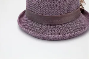Détail de la texture du chapeau violet avec ruban de satin marron et fleur déco