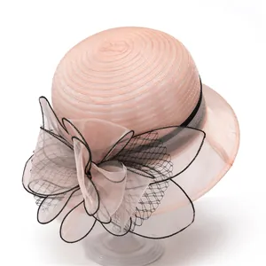 Detail of elegant pink organza hat featuring layered mesh bow and black lace trim