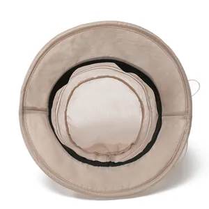Detail of breathable mesh lining and black sweatband inside the beige sun hat