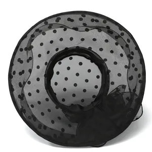 Detail of elegant black organza sun hat featuring polka dots and wavy brim for women