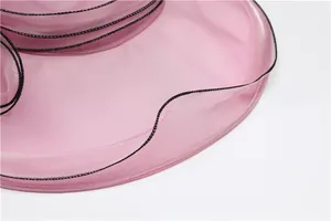 Detailed macro view of pink organza sun hat featuring black stitched wavy edge