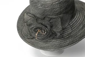 Detailed view of handmade fabric flower and pearl beads on black sun hat brim