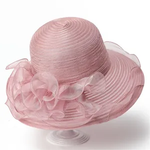 Détail d'un chapeau en organza rose à large bord avec décoration florale pour protection solaire