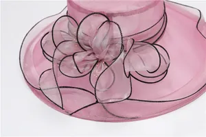 Detail of rose pink organza sun hat with large floral bow and black trim edges