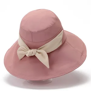 Pink wide brim sun hat with elegant beige ribbon bow for outdoor summer UV protection