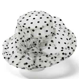 Detailed close-up of large white organza sun hat with black polka dots and mesh flower