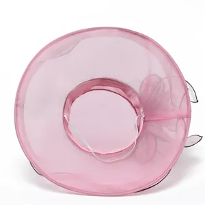 Detailed view of pink organza sun hat with decorative flower and elastic chin strap