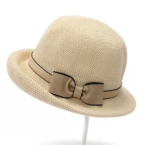 Detailed macro shot of weave texture and bow ribbon on a beige straw sun hat