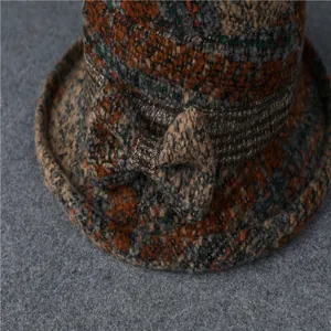 Dettaglio del tessuto in lana a quadri e fiocco decorativo sul cappello da donna