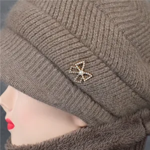 Detail der Winterstrickmütze mit einer Strass-Schleifenbrosche und warmem Fleecefutter