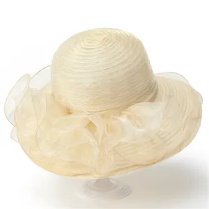 Détail du volant en organza et de la paille tressée sur un chapeau de soleil beige