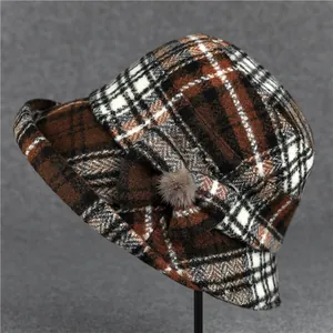 Detailed close-up of brown plaid bucket hat with wool texture and bow decoration