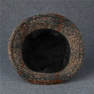 Dettaglio della fodera in tessuto nero e della trama in lana scozzese del cappello