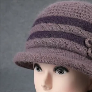 Detalle del gorro de punto violeta con decoración floral y textura cálida
