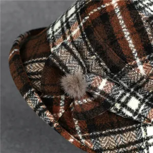 Detail of wool blend plaid bucket hat with fabric bow and small pompom decoration