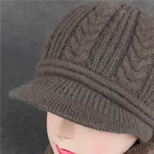 Detail of dark coffee cable knit hat with brim showing fuzzy wool texture on model
