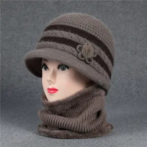 Detalle de flor de punto y pompón de piel en gorro de lana marrón para mujeres mayores