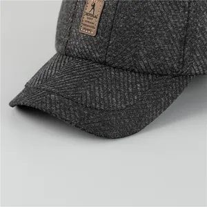 Detail van dikke visgraatstof en leren patch op de winterse honkbalpet voor heren