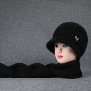 Detail von schwarzem Winter-Strickset mit Mütze und Schal und funkelnder Strassschleife