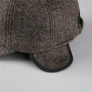 Detail of brown plaid tweed winter hat showing thick wool texture and ear flap protection