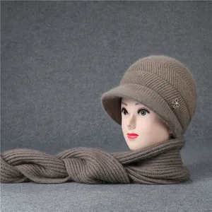 Detaillierte Strickstruktur von braunem Wintermützen und Schal Set mit Strassschleife