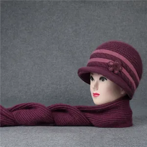 Detalle de conjunto de gorro y bufanda de punto violeta con flor para mujeres mayores