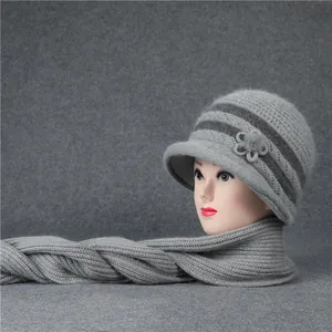 Detalle de gorro de punto gris con adorno floral y bufanda gruesa para invierno
