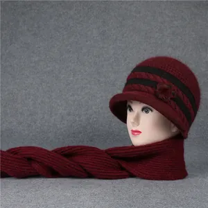 Detalle de conjunto de gorro y bufanda de punto burdeos con cálida decoración floral