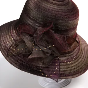 Detail of wide brim sun hat featuring metallic fabric flowers and delicate pearl accents