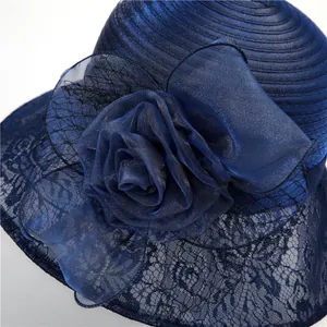 Détail d'un chapeau de soleil élégant en organza bleu marine avec fleurs et dentelle
