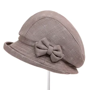Detail of light brown bucket hat with white polka dots and elegant bow decoration