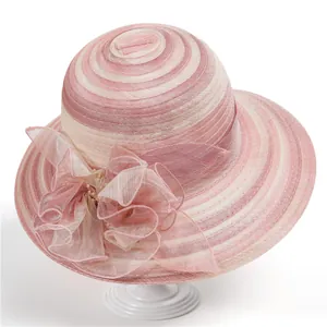 Close-up of elegant pink and beige organza sun hat featuring large floral ribbon bow detail