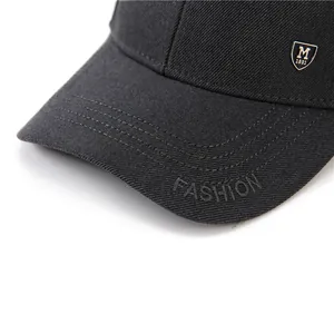 Détail d'une casquette de baseball noire en coton avec broderie et badge en métal
