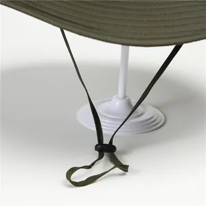 Dettaglio del cappello da sole verde militare con cuciture rinforzate e cordino antivento
