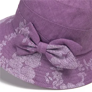 Close-up of purple sun hat detailing lilac bow and delicate white floral print