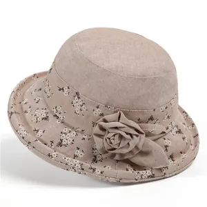 Elegante cappello a secchiello beige per donne anziane con bordo floreale e fiore in tessuto