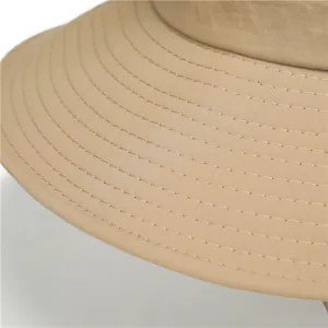 Detalle de costuras reforzadas en el ala ancha de un sombrero de sol caqui para exterior