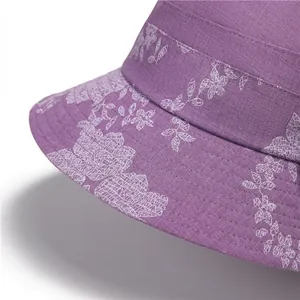 Detail of purple cotton sun hat with white floral pattern and premium stitching texture