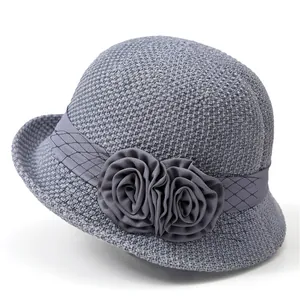 Detail of grey-blue woven sun hat with fabric roses, satin ribbon and polka dot mesh veil