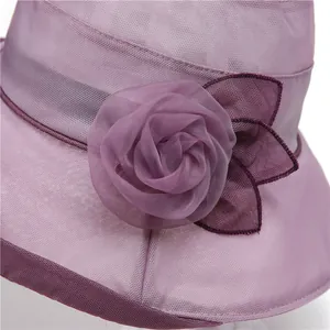 Detailed close-up of a purple mesh sun hat featuring a large elegant 3D fabric flower
