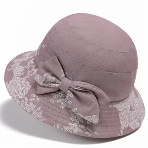 Detailed side view of purple floral sun hat for elderly women with large bow ornament