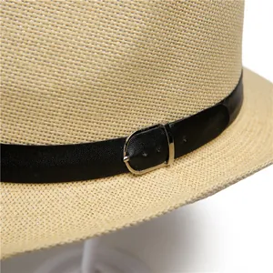 Détail d'un chapeau de soleil beige avec ruban en similicuir noir et boucle métallique