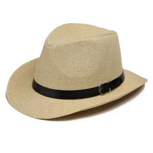 Détail d'un chapeau en paille beige avec bande en cuir noir et boucle argentée