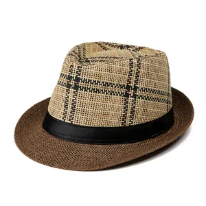 Dettaglio di un cappello fedora in paglia con motivi a quadri neri e nastro decorativo