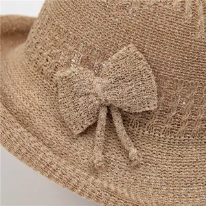 Detailed close-up of khaki knit sun hat featuring a textured bow and woven texture