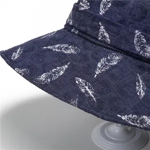 Detail of dark blue sun hat featuring white feather prints and jacquard fabric texture