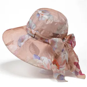 Close-up of floral organza sun hat with large bow detail and elegant peach fabric texture
