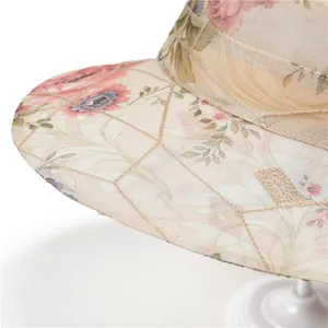 Dettaglio di cappello estivo con tessuto in mesh floreale e cuciture a diamante oro