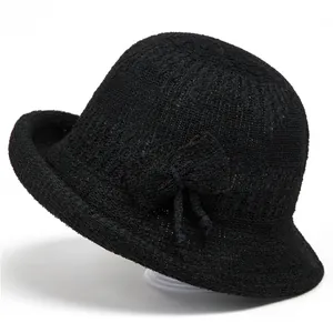 Detailed close-up of a black knit bucket hat featuring intricate crochet texture and a bow